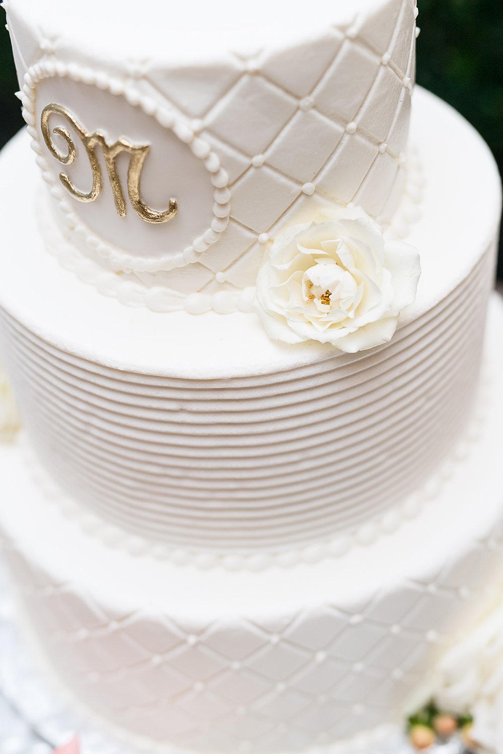 white tier wedding cake with gold lettering