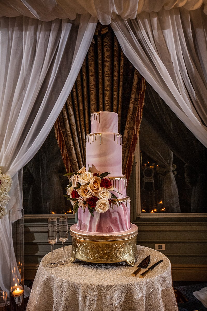 pink and white wedding cake on gold cake stand