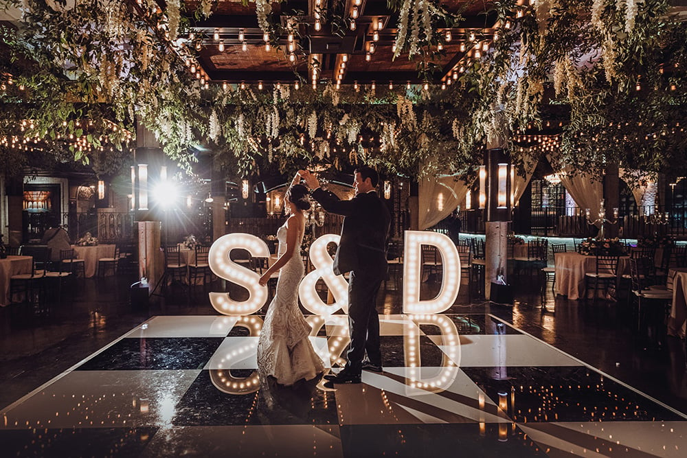 first dance at wedding reception with floral ceiling
