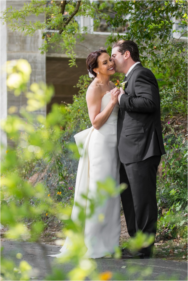 Bride in strapless gown holding hands with groom in suit outside their wedding venue in Houston, Texas.