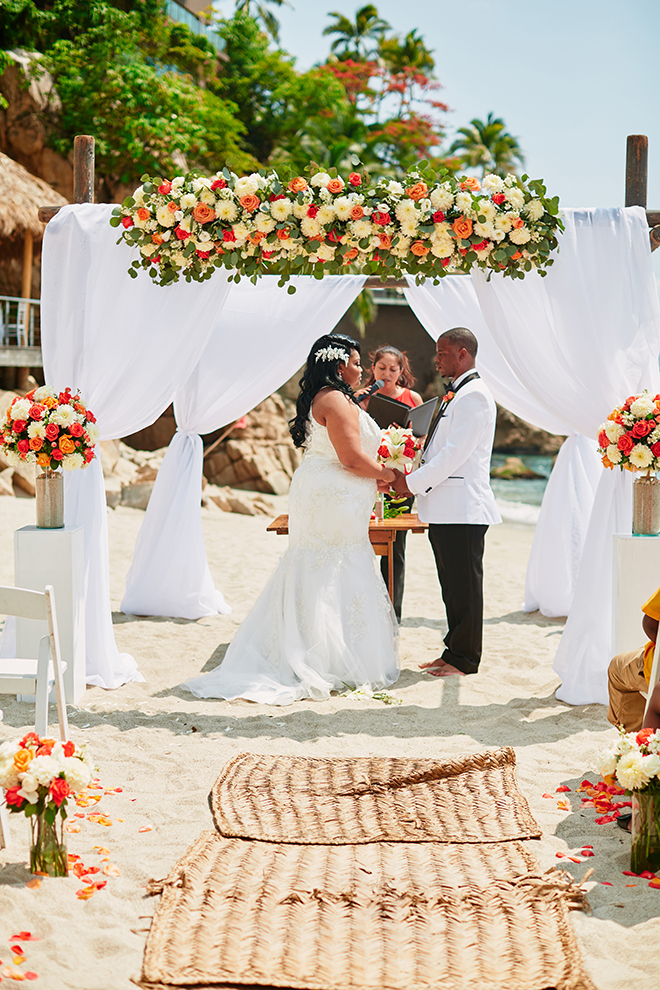 beach destination wedding, wedding ceremony, exchanging vows, floral wedding canopy, summer wedding, Mexico