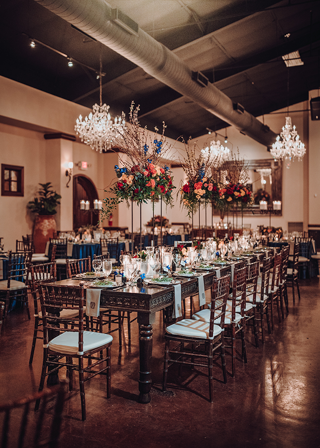 reception decor, madera estates, blue linens, spanish-inspired wedding, chandeliers, candle centerpieces, greenery, table setting, wedding table