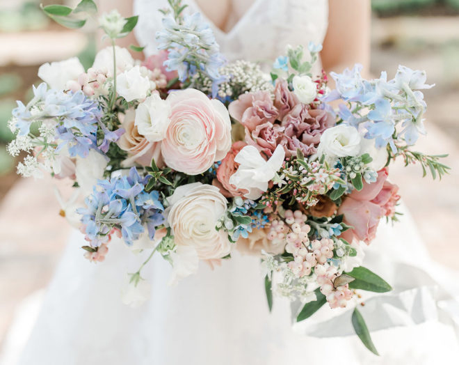 Close-up of blooming bridal bouquet- blush, lavender and shades of pink/mauve florals with sprays of greenery