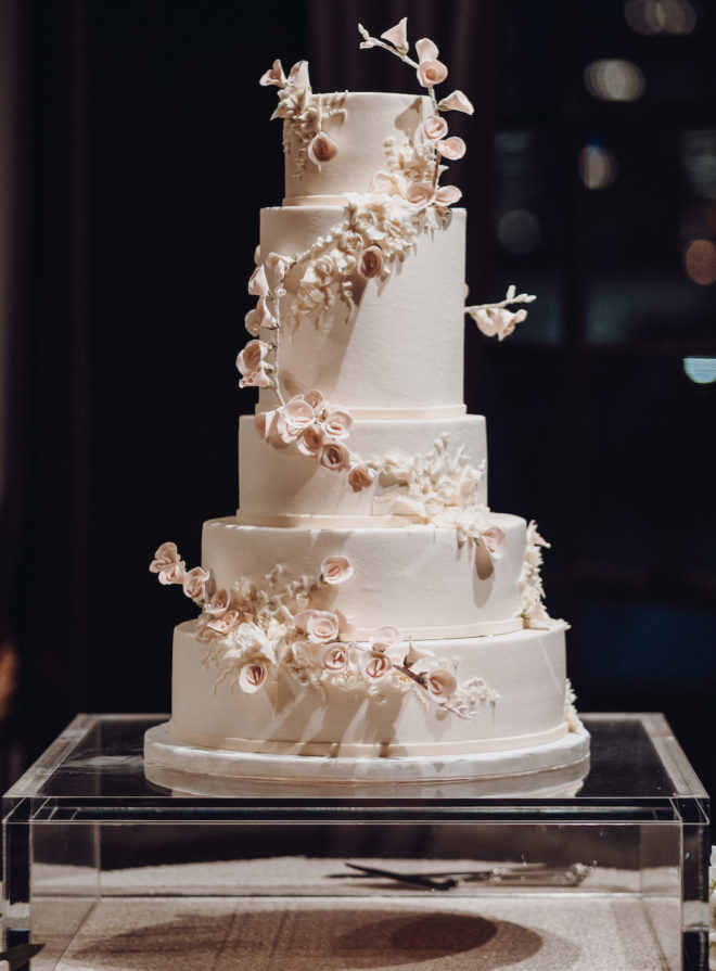 Elegant 5 tiered cream and blush colored wedding cake with delicate fondant roses 