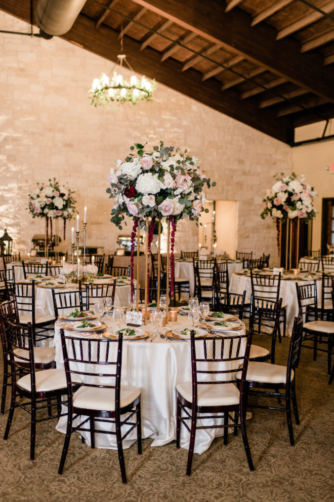 Blush and wine floral reception table arrangement. 