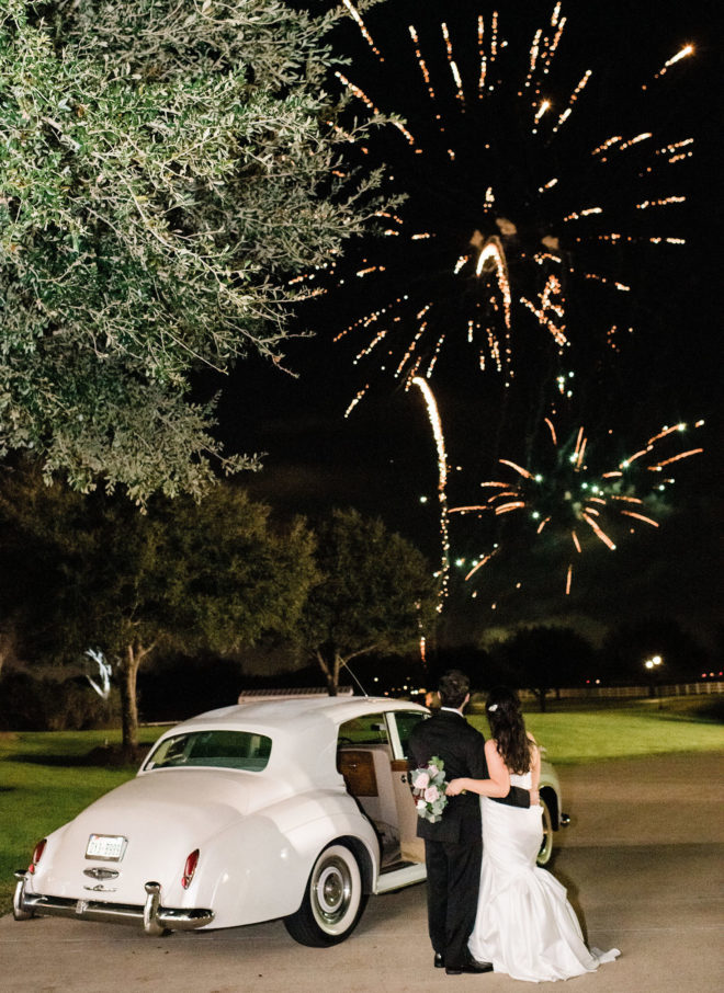 Bride and groom standing by Rolls Royce car and watching fireworks in distant at Briscoe Manor