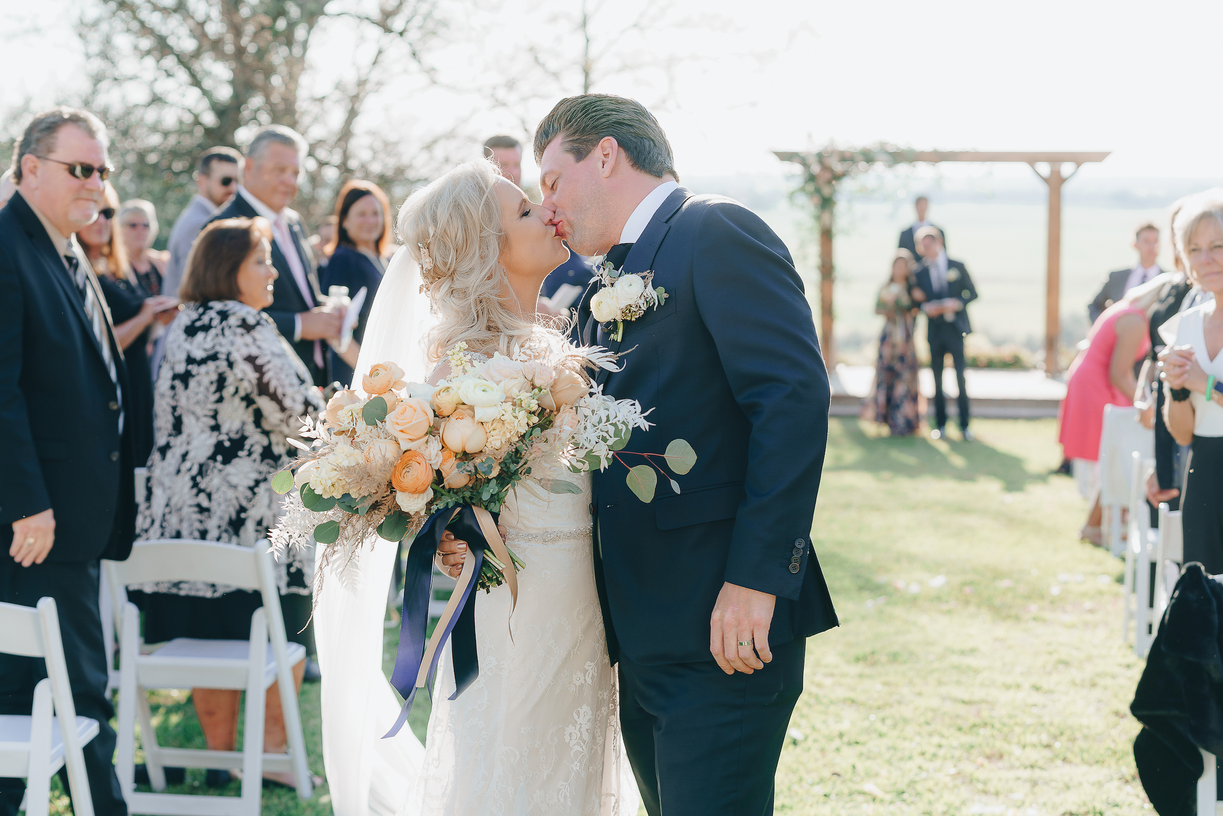 Bride and Groom kissing at the end of the aisle.