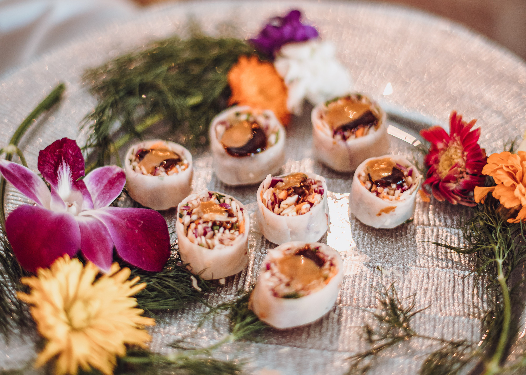 Miso vegetable spring roll wedding appetizer garnished with fresh botanicals, a 2021 wedding trend.