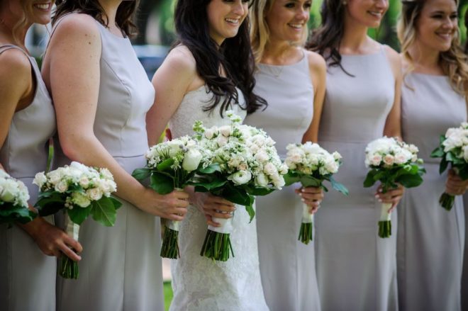 Bridesmaids white rose floral bouquets.