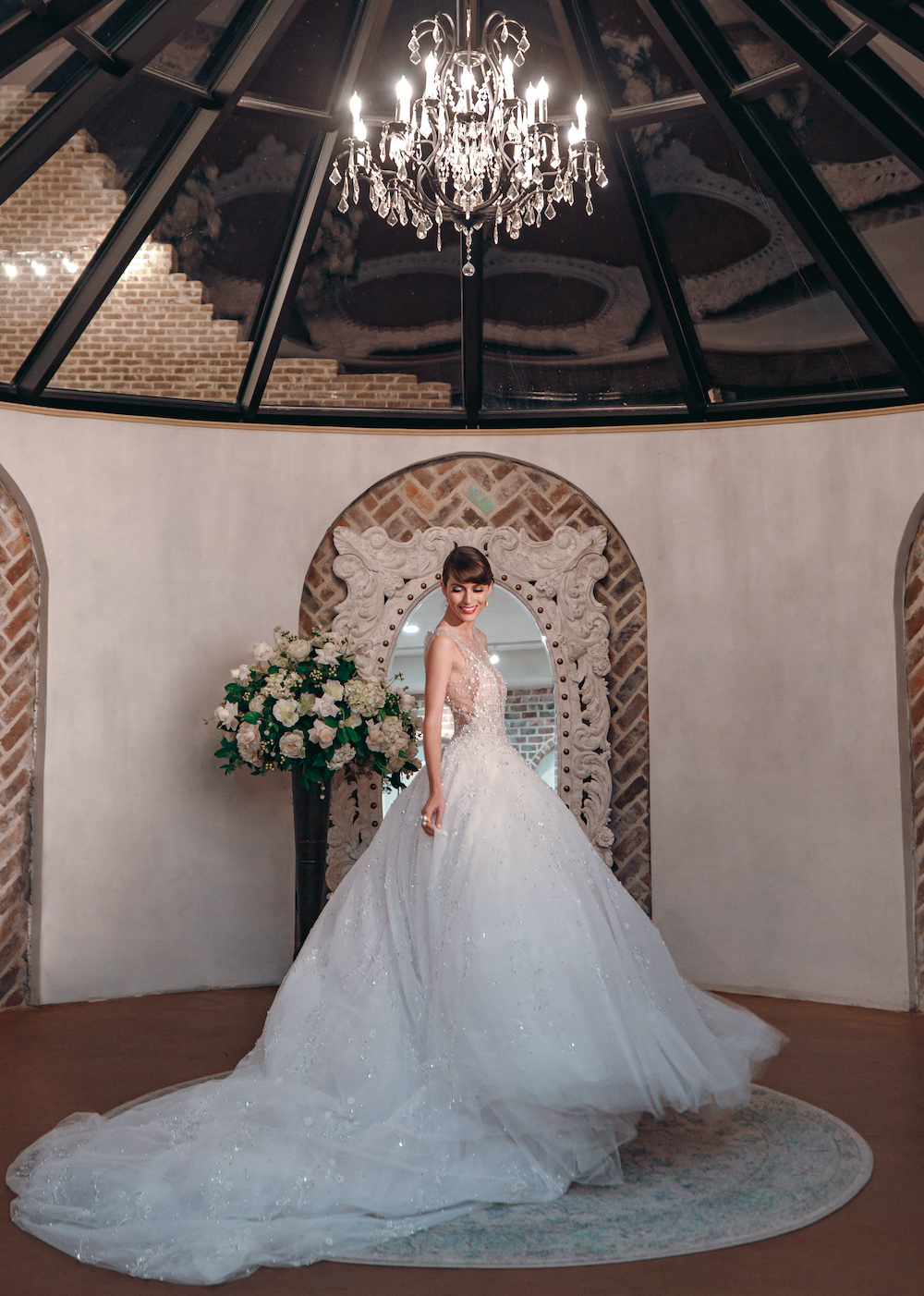 Model wearing white ballgown by Ines Di Santo inside a bridal suite at wedding venue Iron Manor in Conroe, Texas.