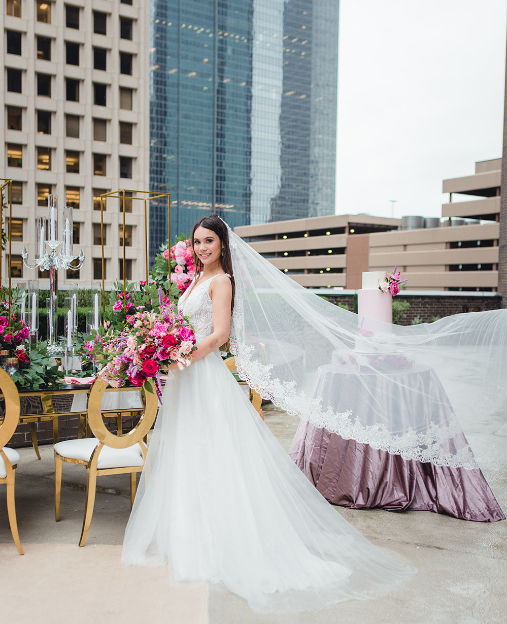 Our bride holds her bridal bouquet in front of a reception table while her veil gracefully catches the wind. 