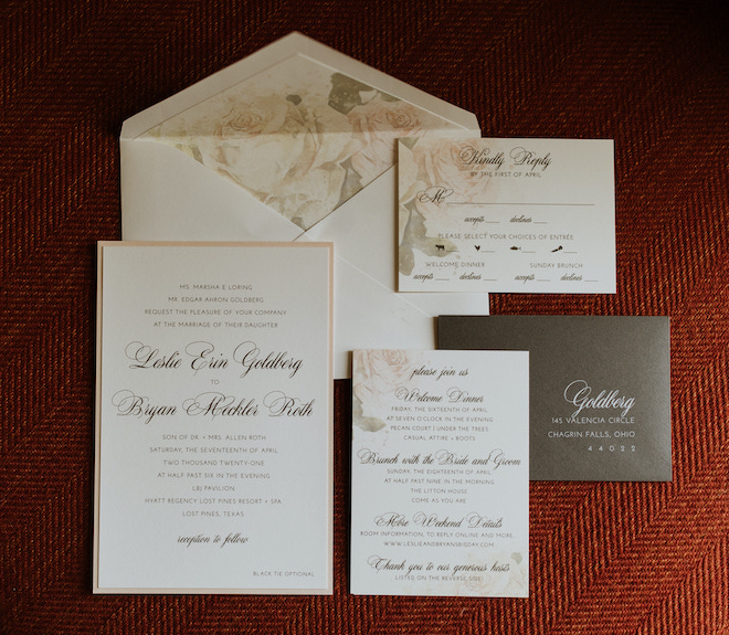 Invitation suite with soft blush rose motif and cursive font provided by Bering's Hardware in Houston. 