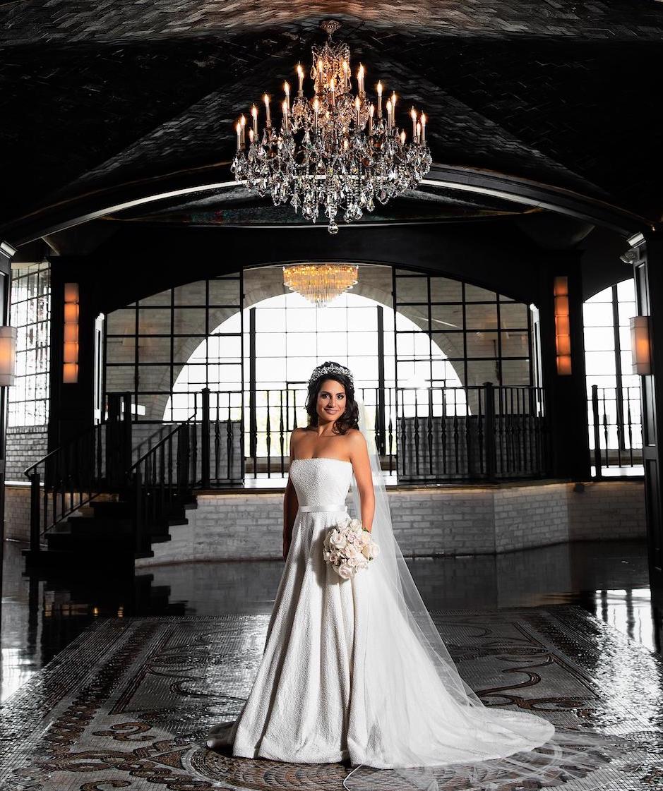 Bride at the Astorian with chandeliers hanging above.