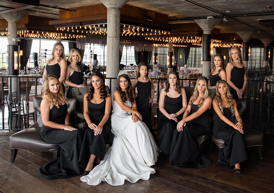 Bride and bridesmaids in fitted black floor length dresses at The Astorian.