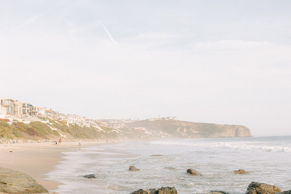 This beach elopement was set on the beach in Orange County, California, where the waves roll over rocks and sand. 