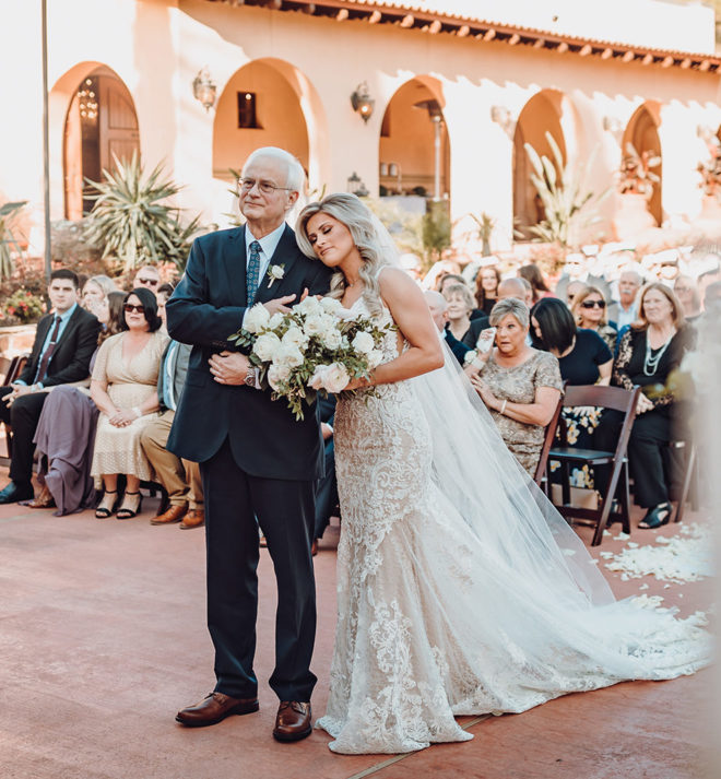 Bride leaning her head on her fathers shoulder at an alfresco ceremony at Madera Estates in Conroe, Texas.
