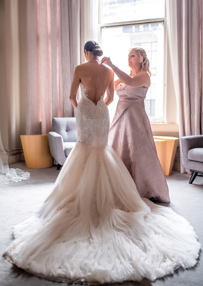 Mother of the bride is helping the bride get ready in an intimate bridal lounge at The Corinthian Houston. 