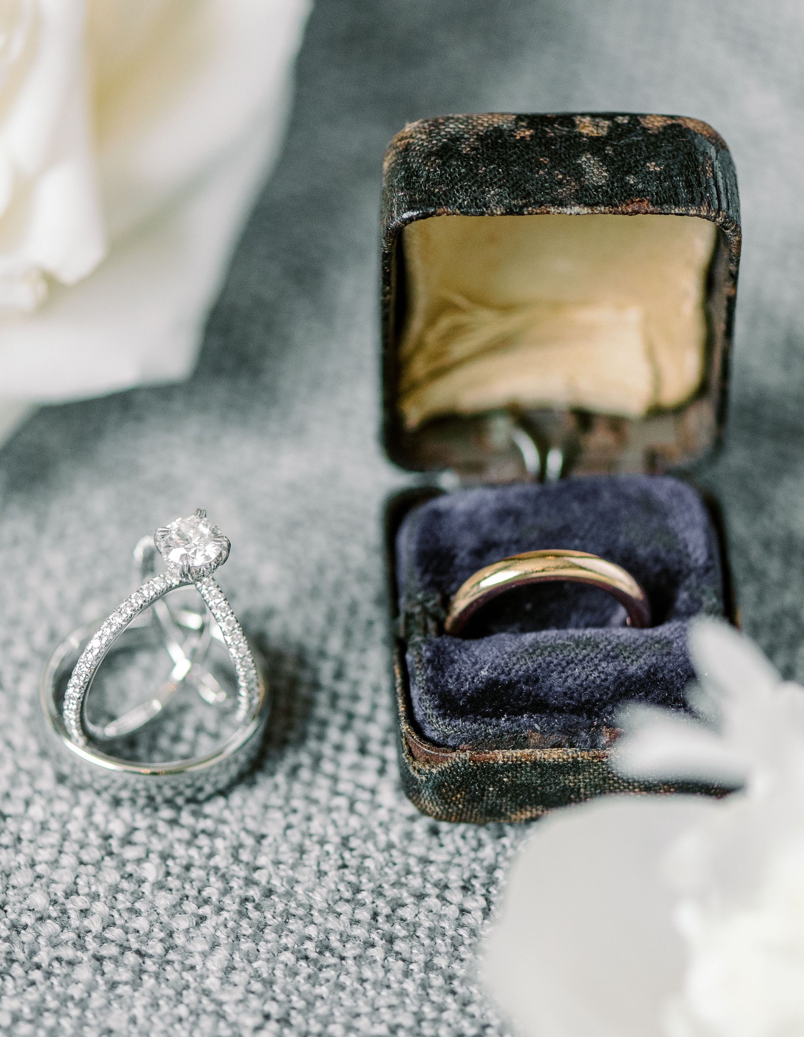 The bride's classic wedding ring and the groom's ring beside each other.