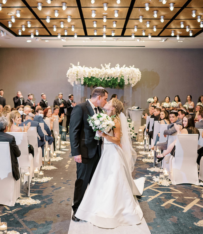 Bride and groom kissing before they leave the wedding ceremony.