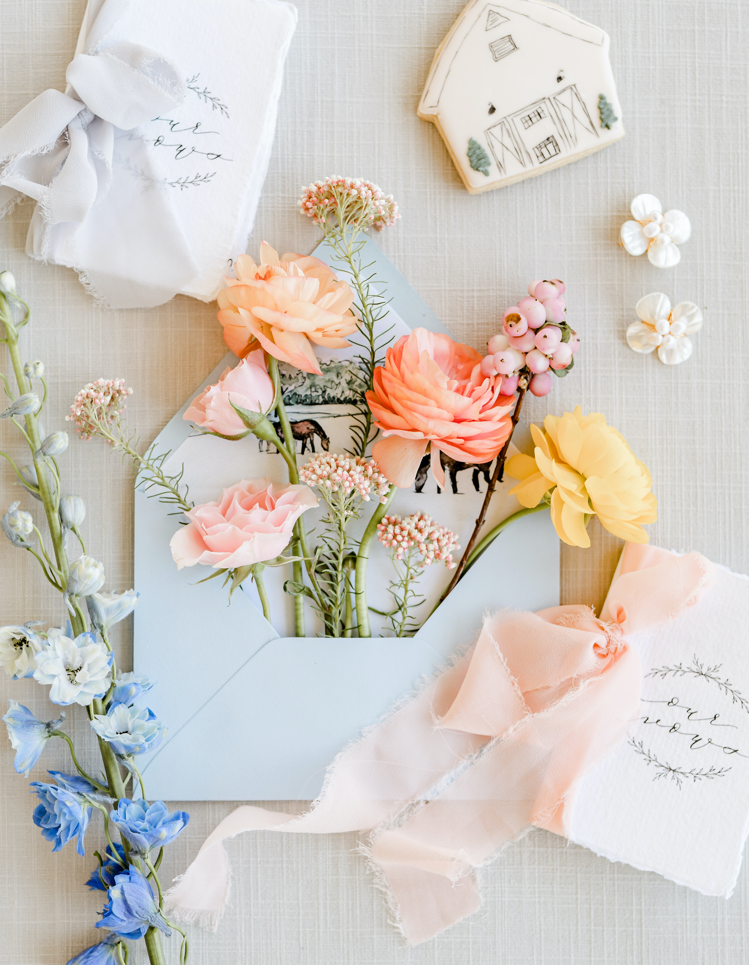 Colorful flowers flow out of a blue envelope for Crystal and Micheal's friendly spring wedding.