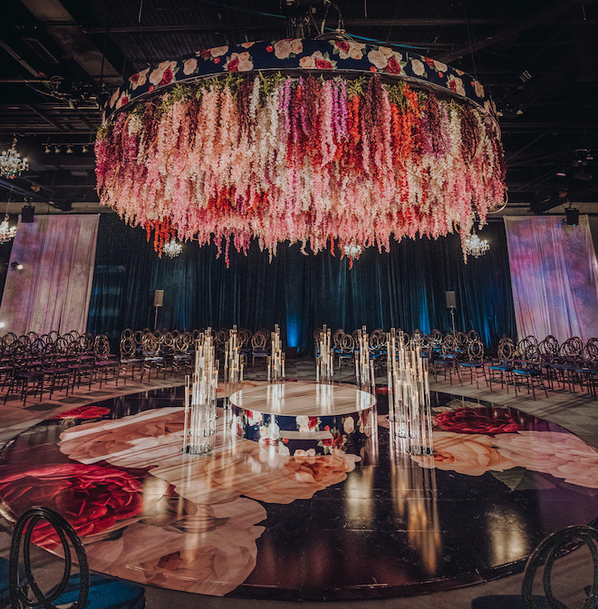A vibrant canopy of flowers hangs over the dance floor in red, pink and purple hues at downtown Ballroom at the Bayou Place