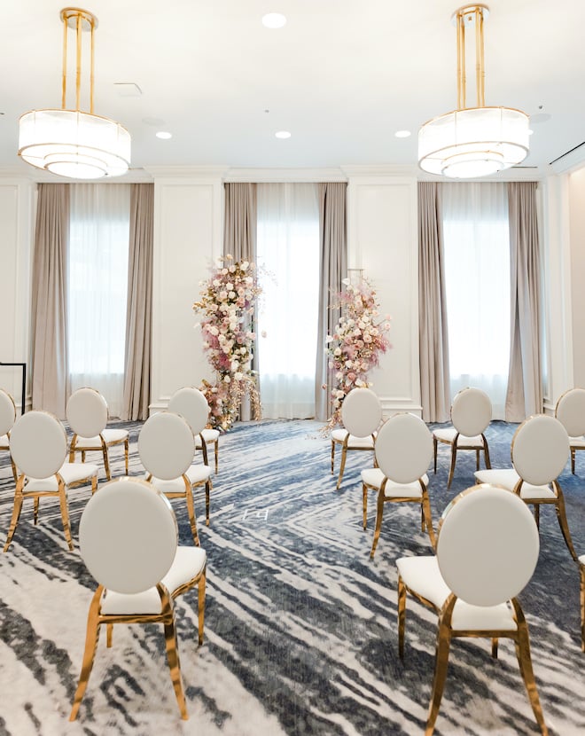 The gold floral filled wedding ceremony set up at a downtown venue Four Seasons Houston.