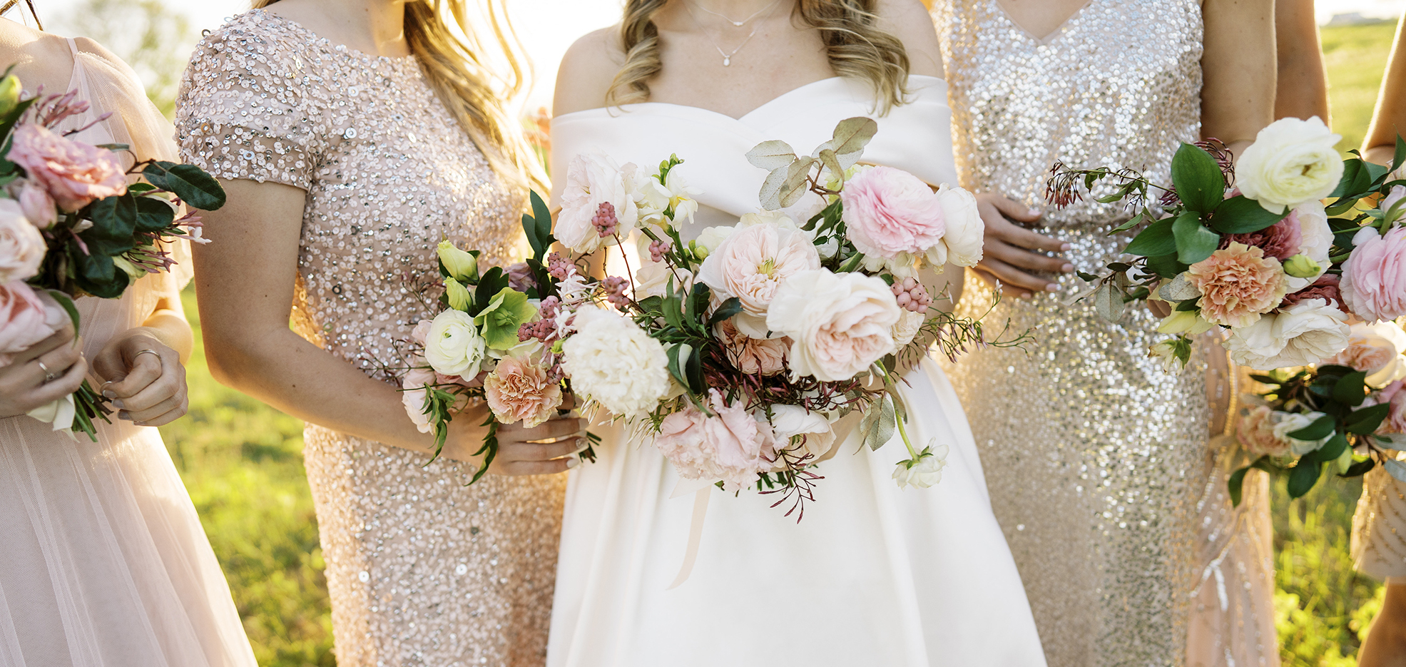 An up close photo of the bride's wedding bouquet with her bridesmaids behind her.