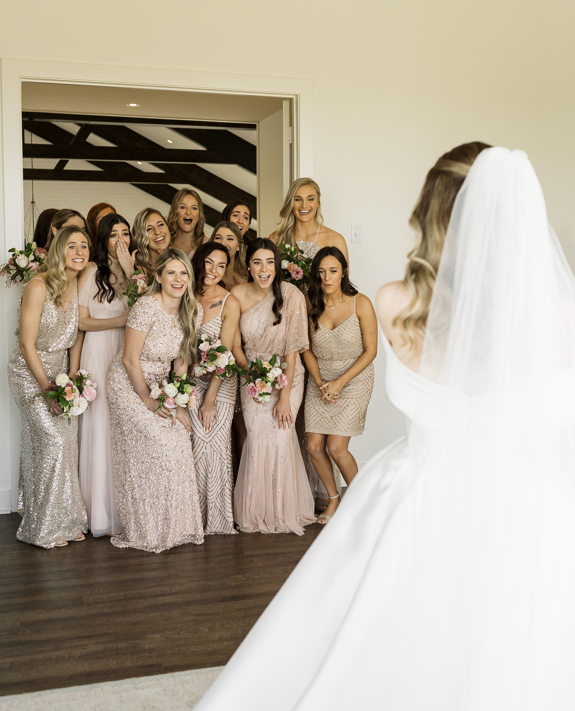 The bride reveals her final look to her bridesmaids.
