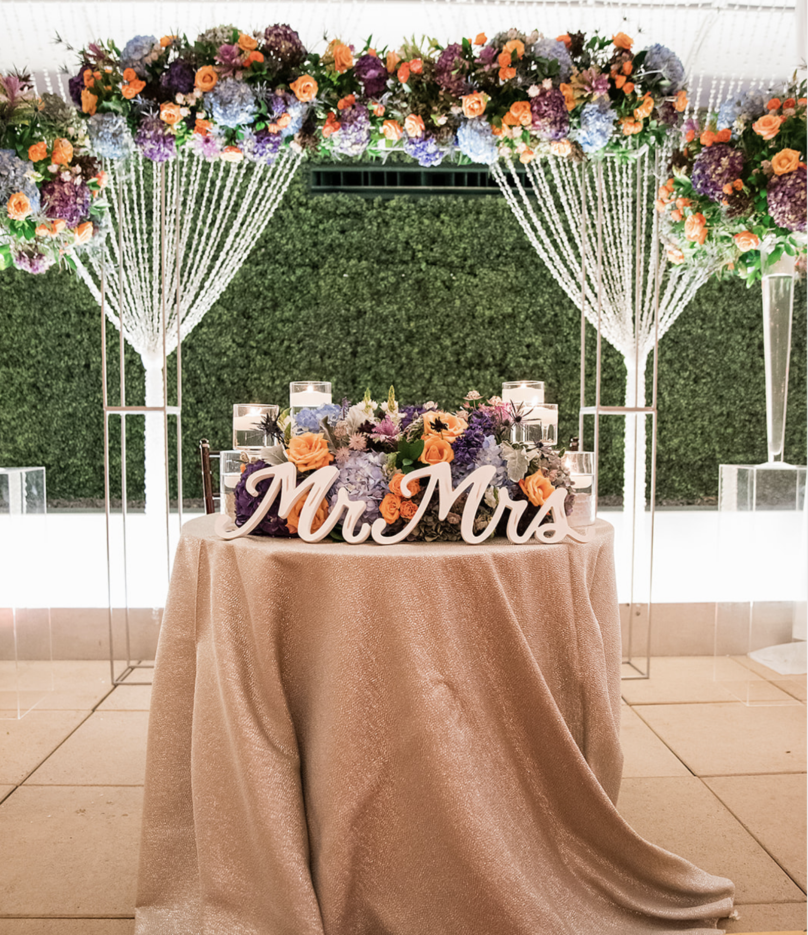 A sweetheart table decorated with floating candles and flowers at the Sam Houston Hotel.