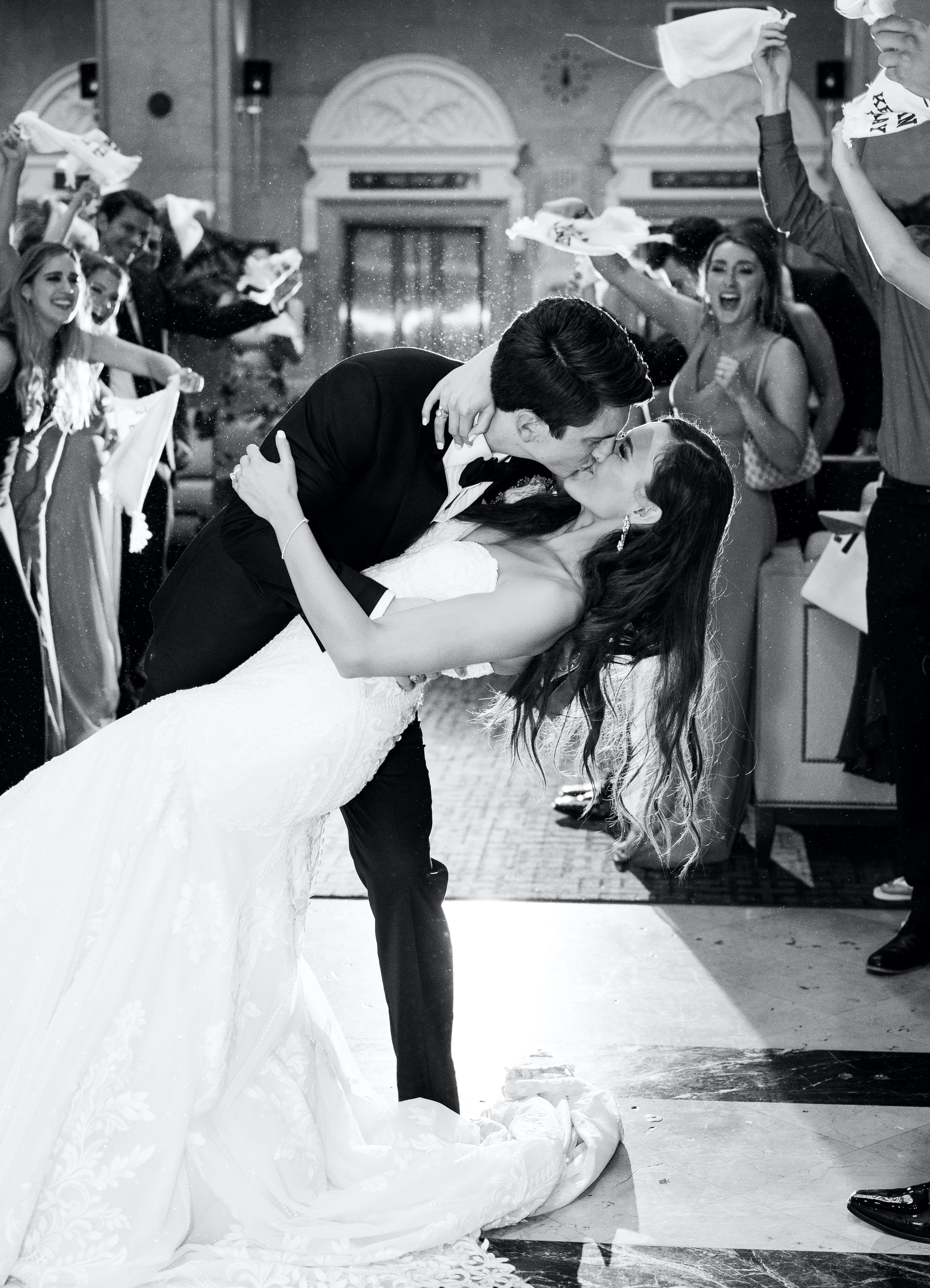 The bride and groom kiss before they drive away from their elegant rainy wedding.