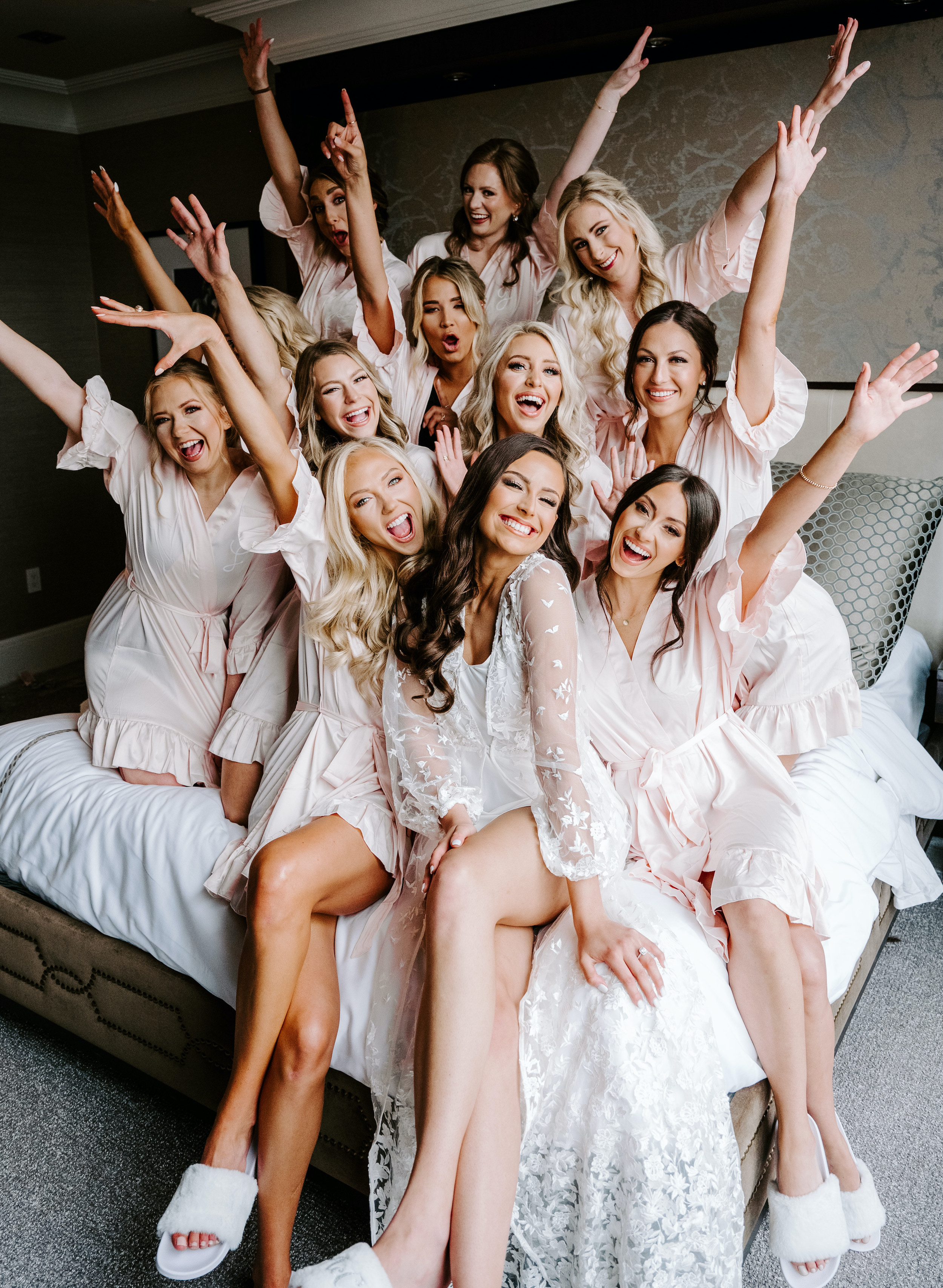 The bride is smiling with all her bridesmaids before the elegant rainy wedding.