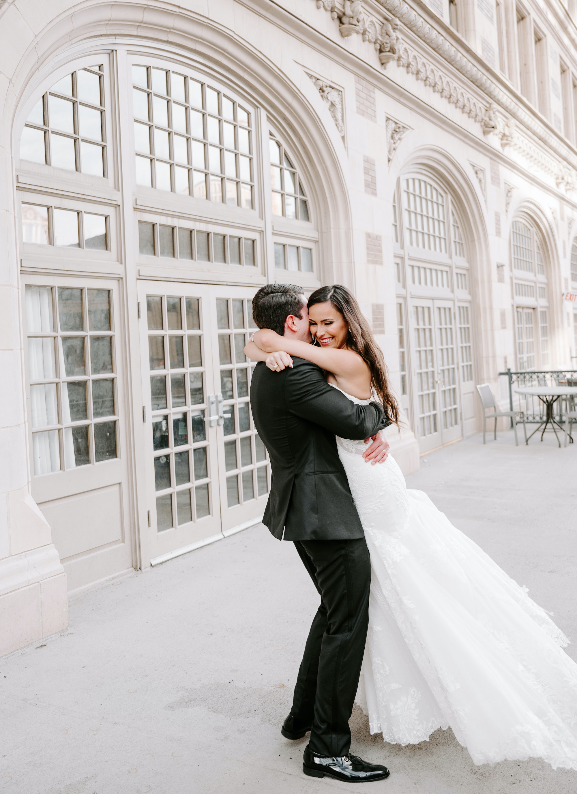 The groom hugs his bride on the terrace of The Crystal Ballroom in downtown Houston.