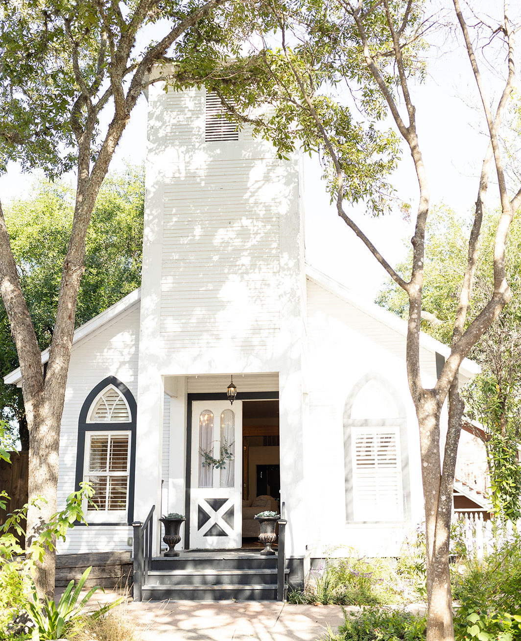 One story historic building with open door in an outdoor courtyard at The Kendall Hill Country Inn wedding venue in Boerne, TX. 