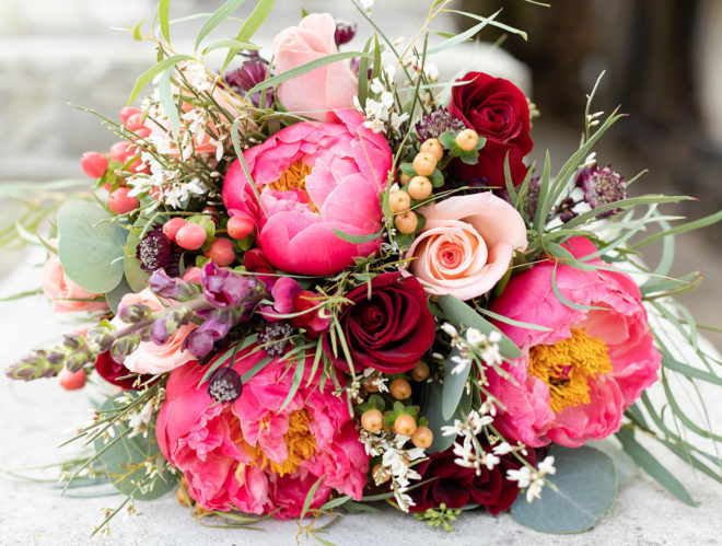 Bridal bouquet of pink and red florals with greenery at a wedding styled shoot at a Boerne wedding venue. 