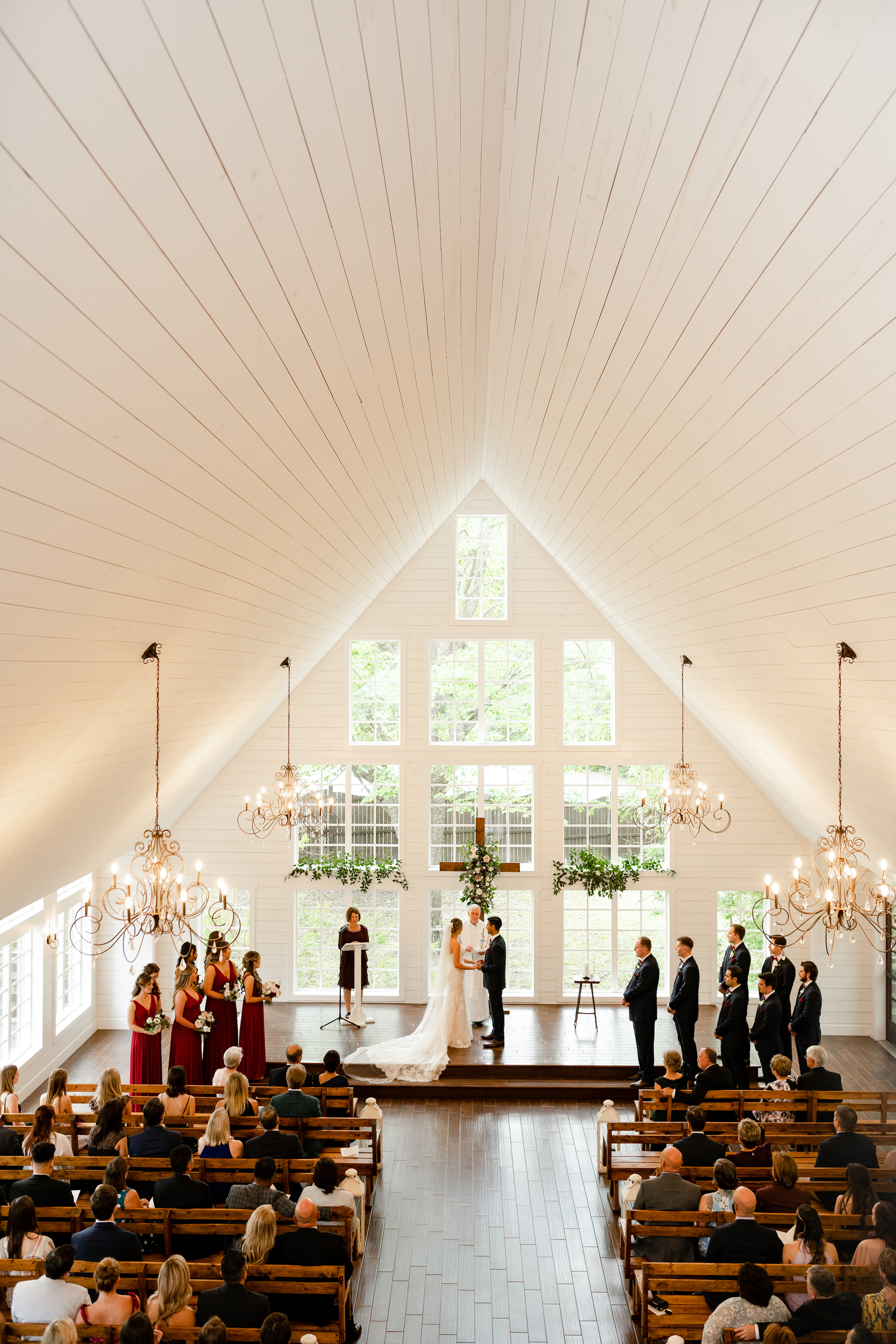 The bride and groom stand at the altar during their wedding ceremony at The Carriage House in Montgomery, TX