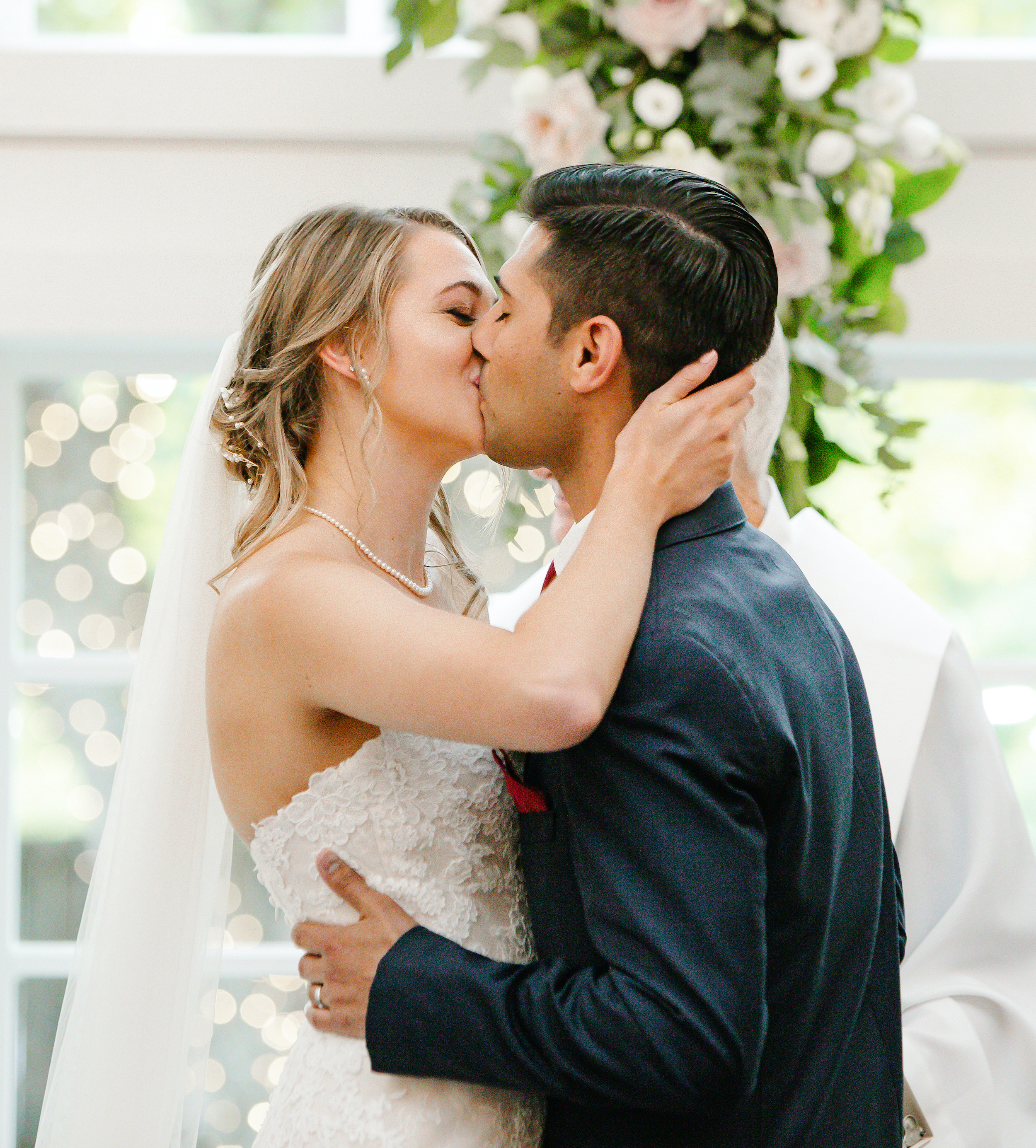 The bride and groom kiss at the altar at the wedding ceremony.