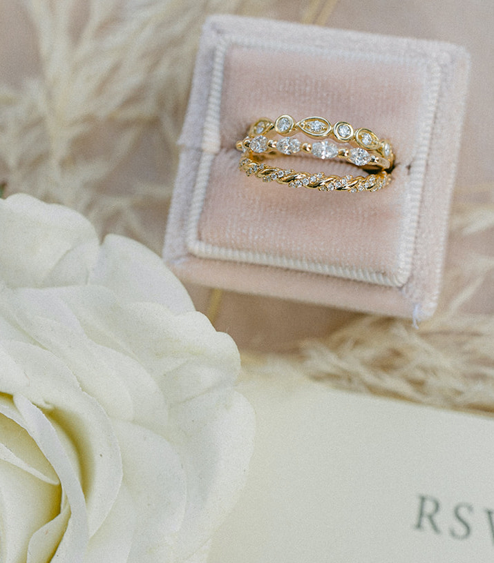 The bride's wedding bands are gold with dainty diamonds encrusted along the band.