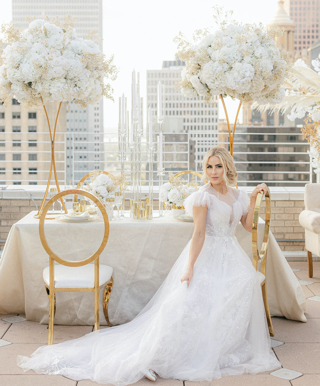 The bride is seated at the dinner table on the rooftop in Houston.