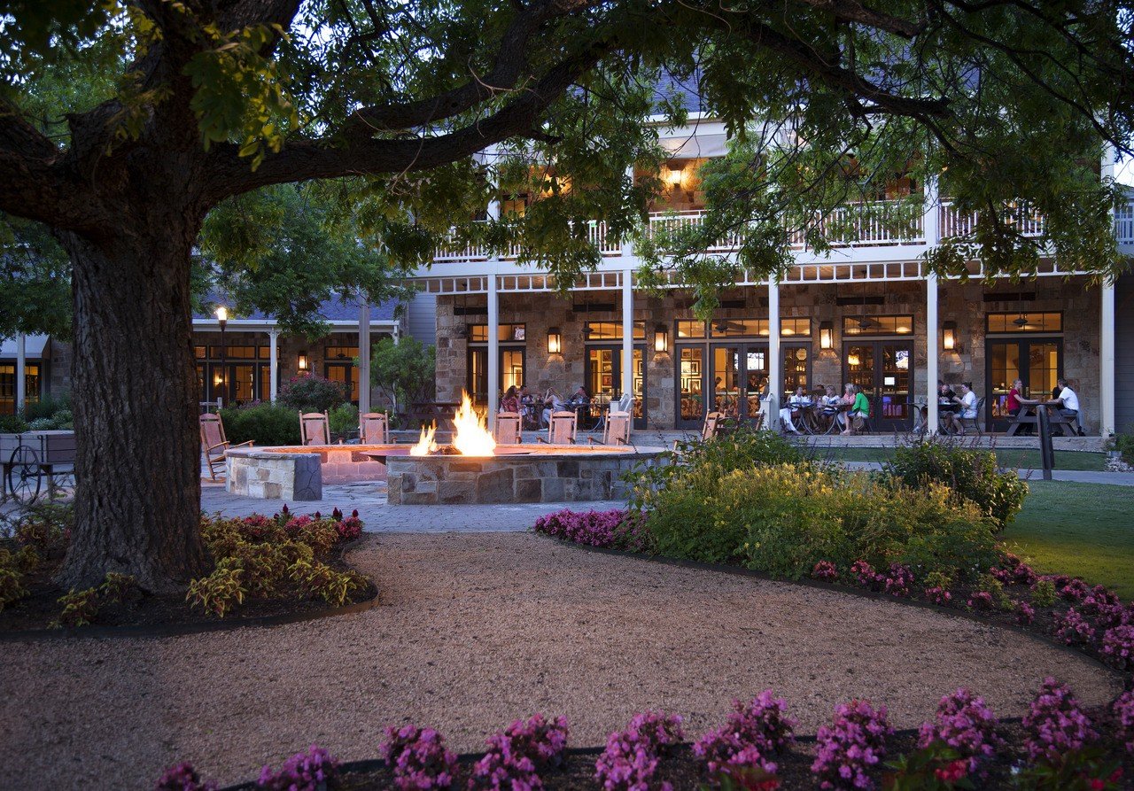 An outdoor view of a fire and patio and a hill country resort in Lost Pines.