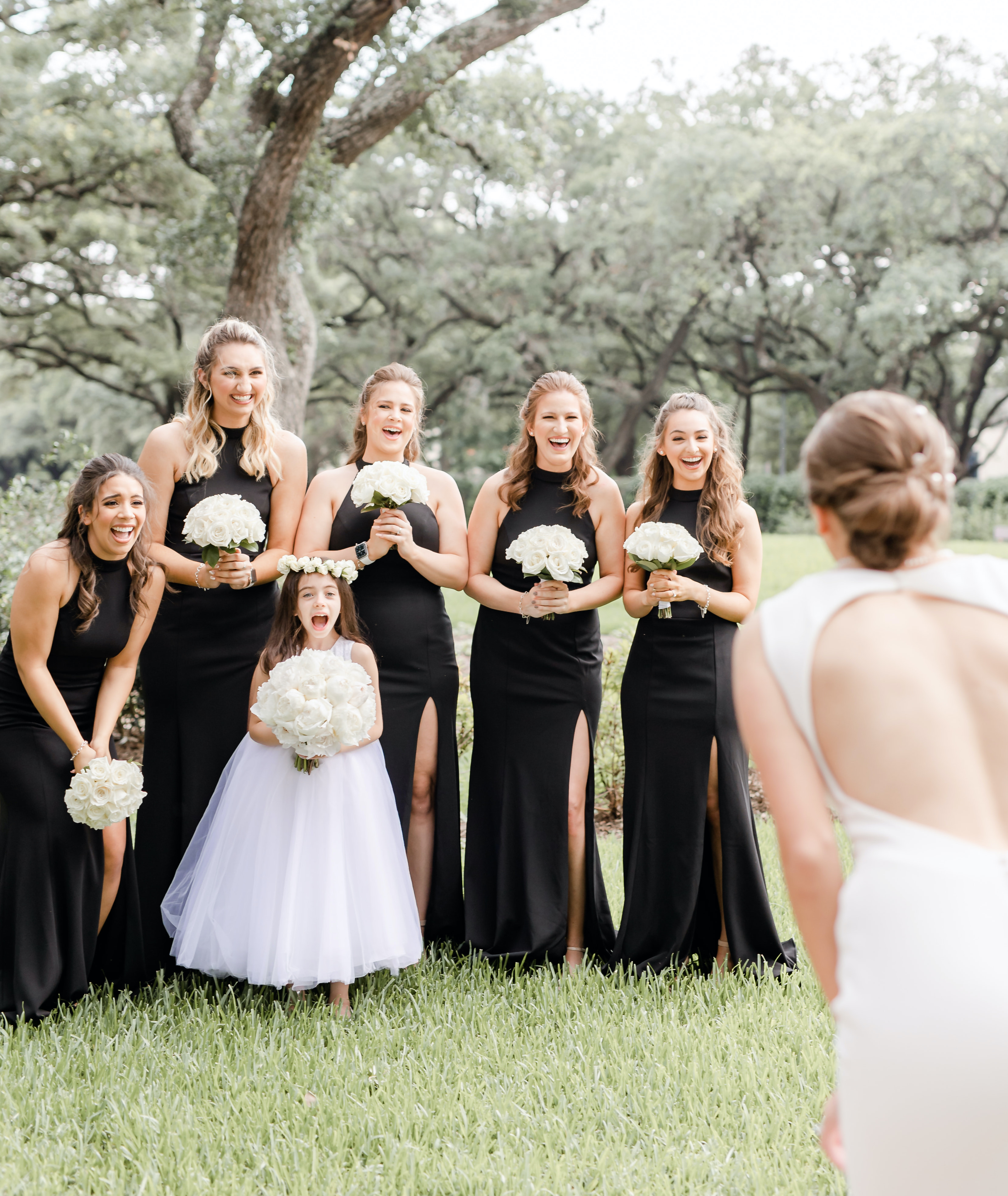 The bridesmaids smile as they see the bride's final wedding look for her ivory, black and champagne wedding in the Houston museum district.
