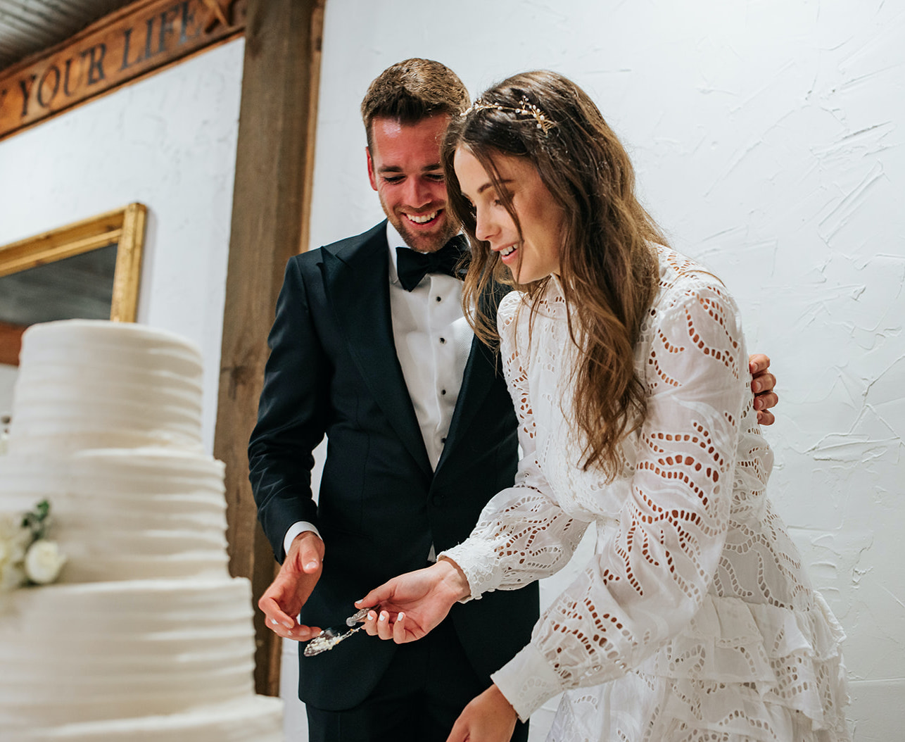 The bride and groom cut into their white wedding cake at their winter wedding in College Station, TX.