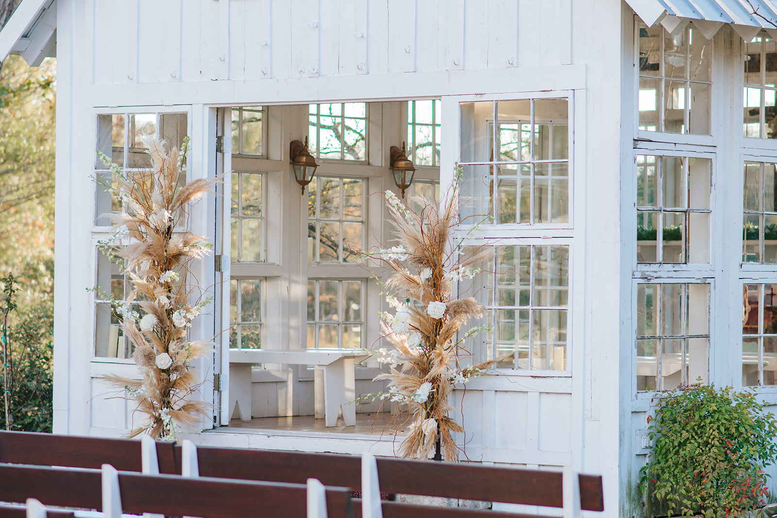 A close up photo of the white chapel at 7F Lodge in College Station, TX. The chapel is decorated with neutral Pampas grass and white roses.