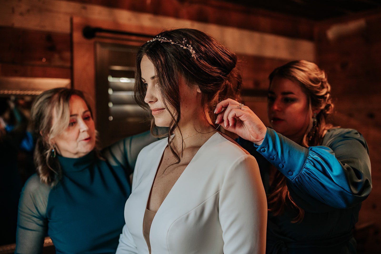 The bride's mother and another woman help her get ready for her winter wedding at 7F Lodge in College Station, TX.