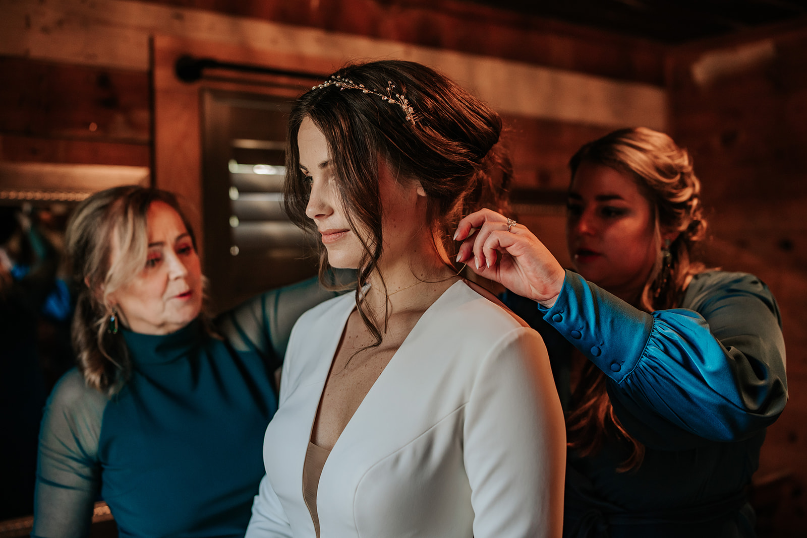 The bride's mother and another woman help her get ready for her winter wedding at 7F Lodge in College Station, TX.