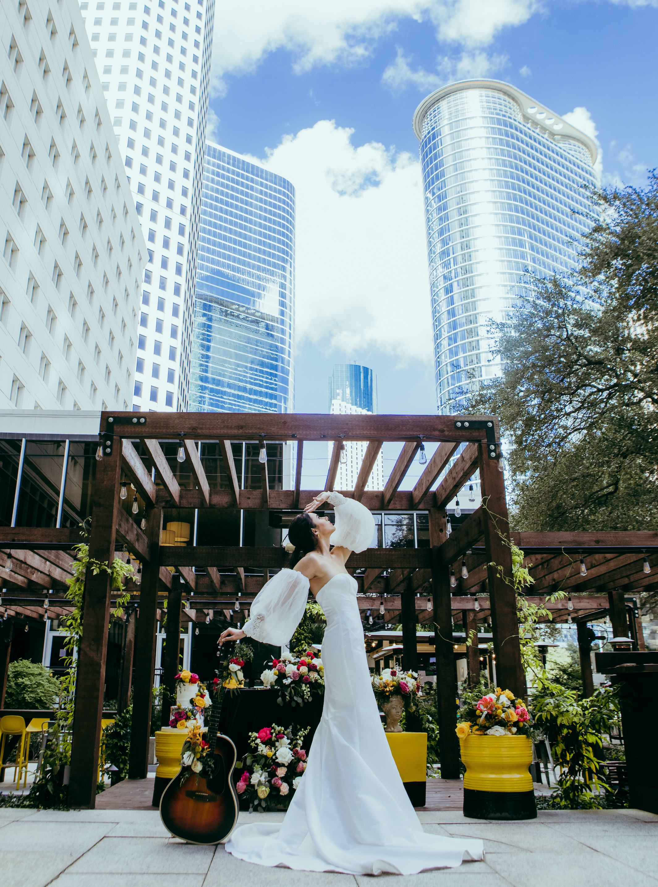 The bride leans on a guitar outside of The Whitehall Hotel in Houston, TX.