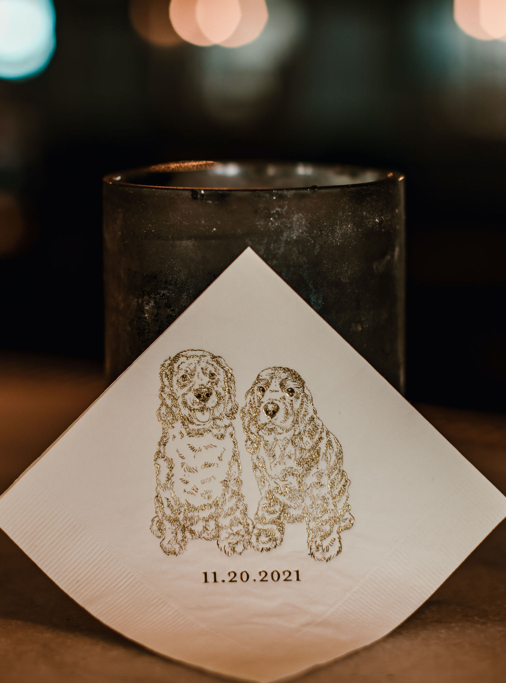 The bride and groom's dogs are etched with gold on napkins at their wedding reception at The Astorian in Houston, TX.