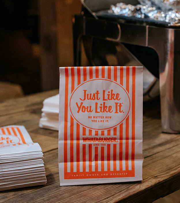 The bride and groom have Whataburger bags at their winter wedding for guests to grab when they leave 7F Lodge, a wedding venue in College Station, TX.