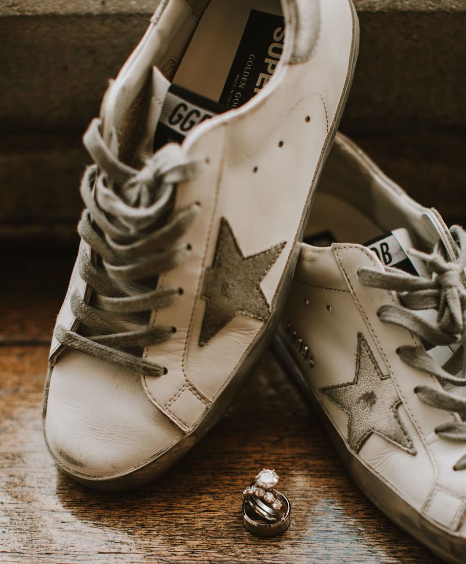 A bride wears white golden goose shoes on her wedding day at The Astorian in Houston, TX.