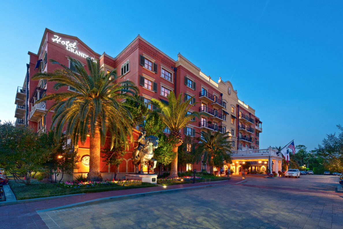 Hotel Granduca at dusk in Houston, Texas. The hotel venue has palm trees around it and is italian inspired.