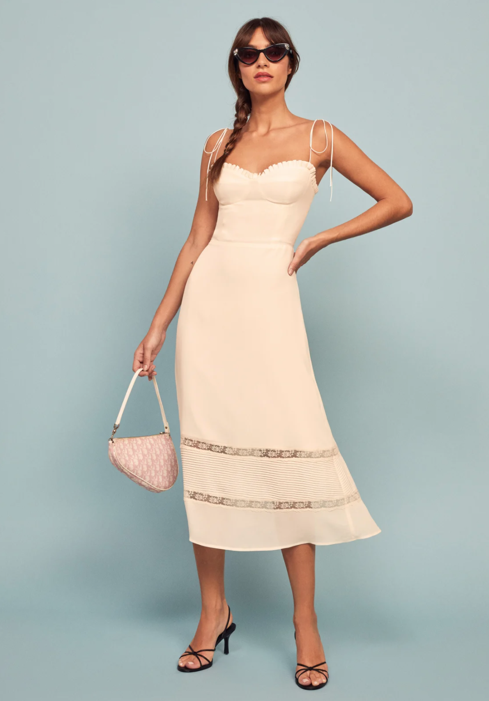 An ivory midi dress with tie spaghetti straps and lace details for a bride for her bridal shower. Dress is the Ronan Dress from Reformation
